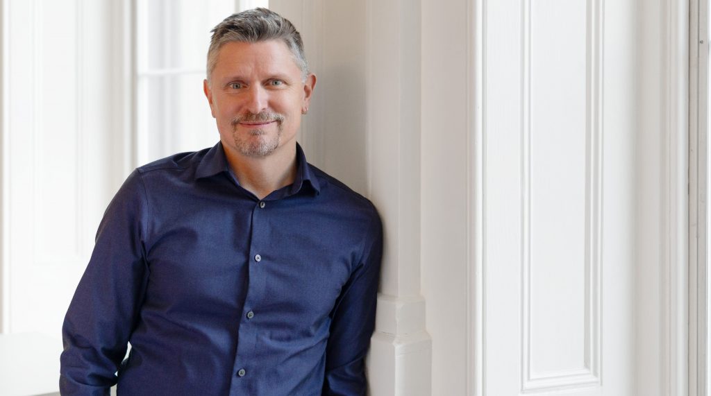 man in blue button-down shirt smiling