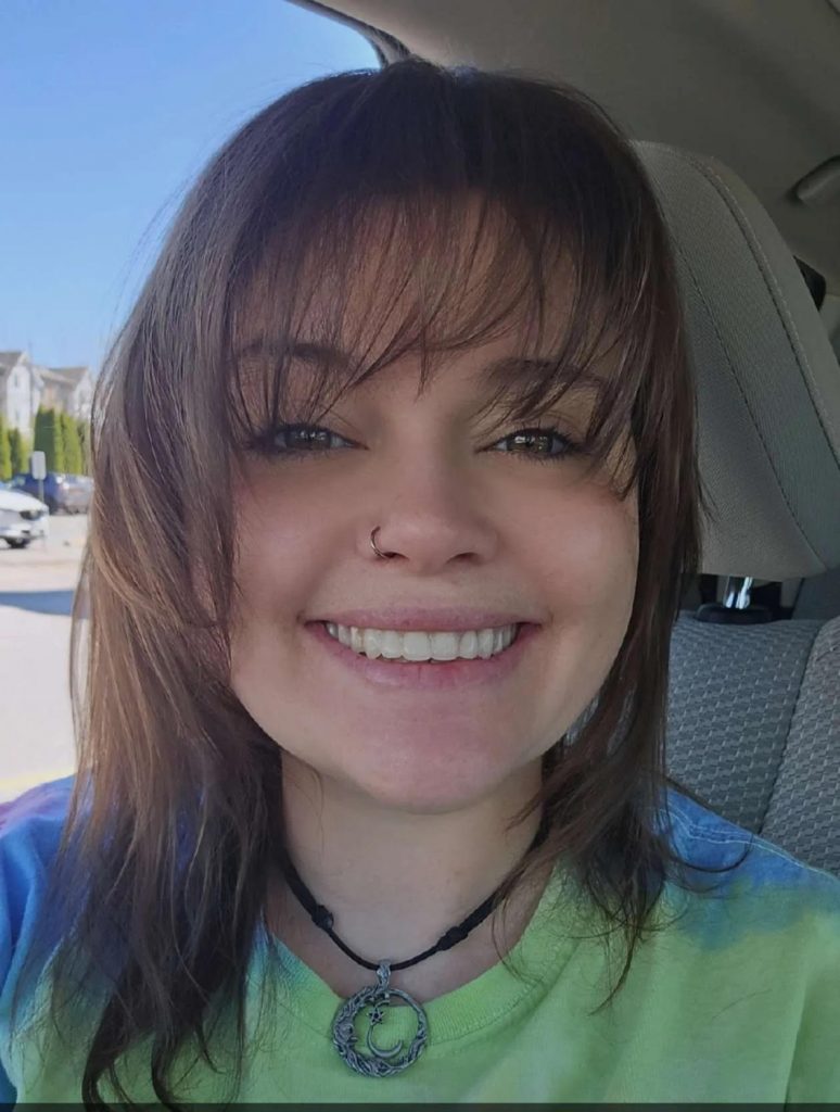 Woman with green shirt smiling at camera